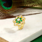 Load image into Gallery viewer, Silver Gold plated ring with green gemstones on a white surface with a peacock feather in the background
