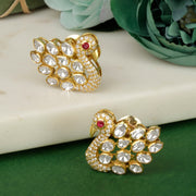 A pair of silver earrings with a peacock shape adorned with white stones and a red stone on the top part of the tail