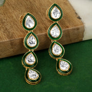 A pair of silver earrings with green enamel and white cubic zirconia displayed on a wooden surface with a green background.