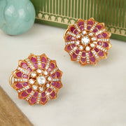 Decorative silver earrings with pink and gold design on a white surface