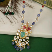 Silver Decorative necklace with beads and gemstones on a peacock feather background